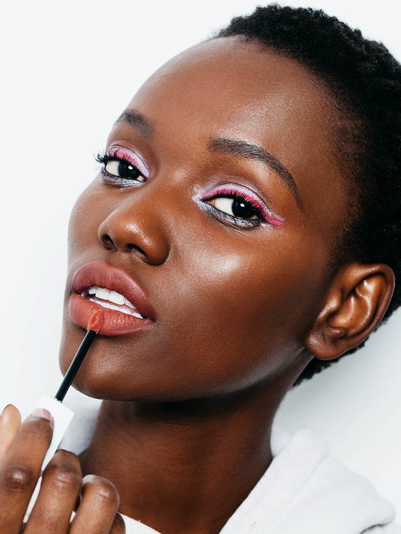 Donna con look per le feste che applica rossetto Matte Ink