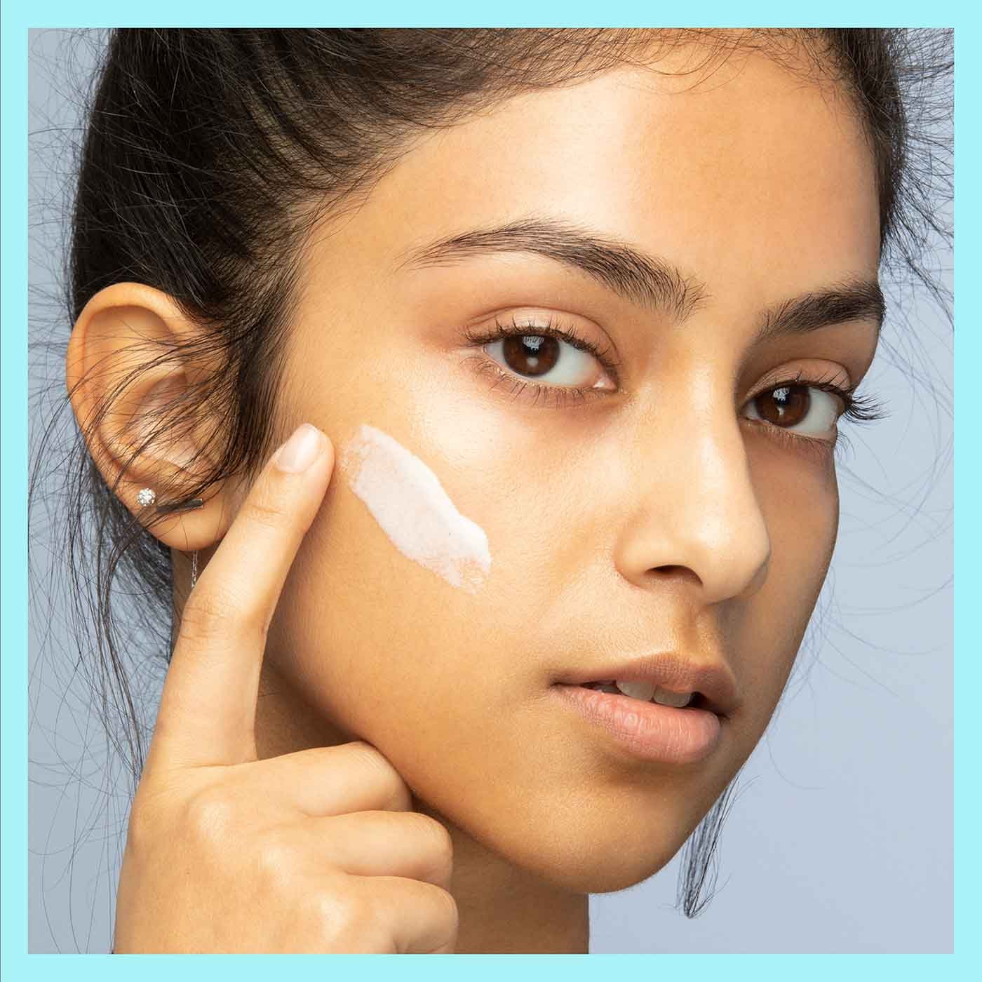 Donna che applica primer sul viso