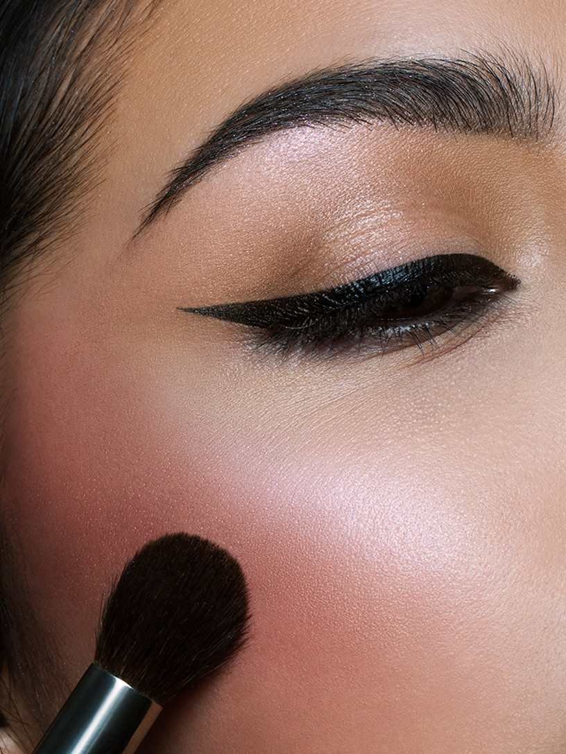 Donna che applica blush sulle guance