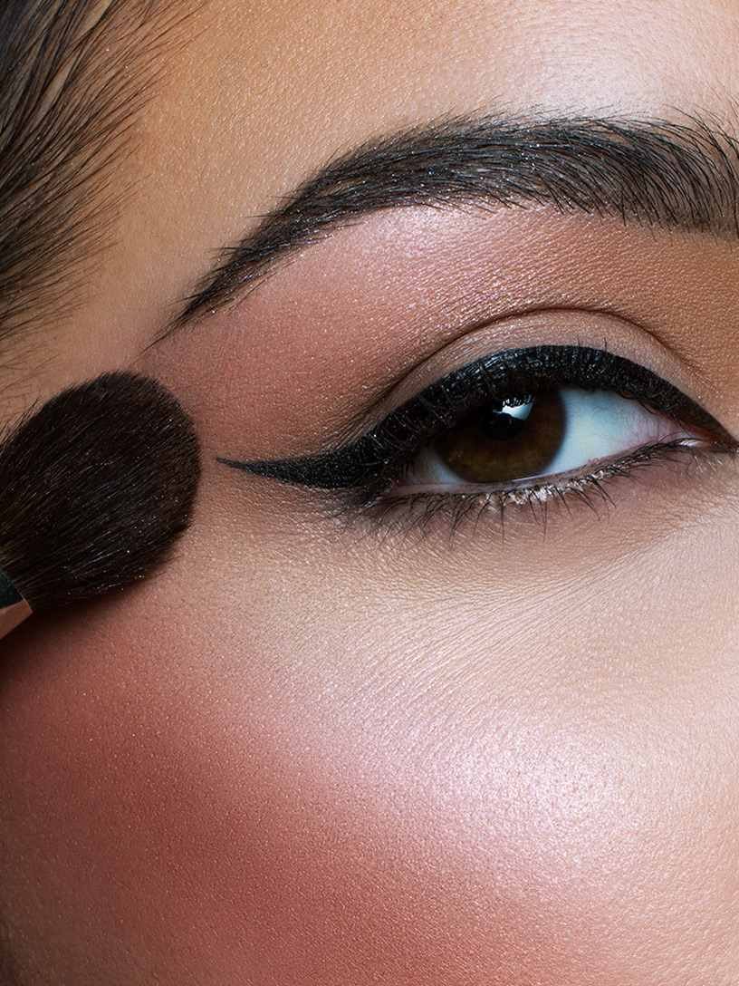 Donna che applica il blush verso l’arcata sopraccigliare